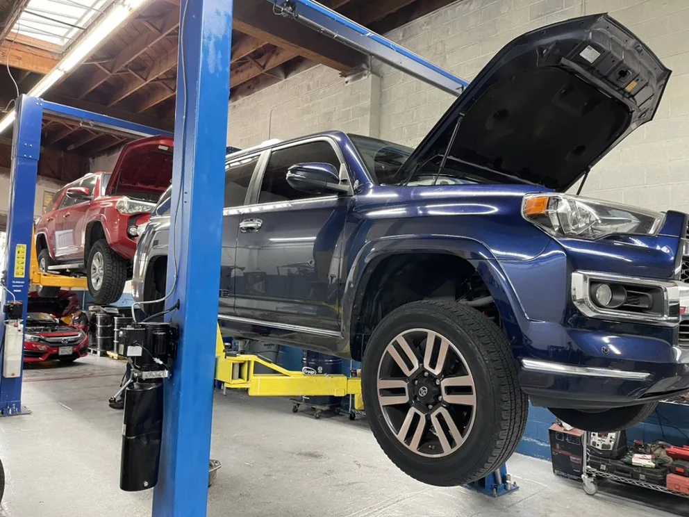 Two SUVs raised on the lifts in the T-21 service bay
