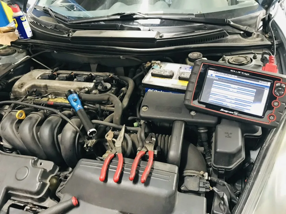 A diagnostic scanner connected under the hood of a car