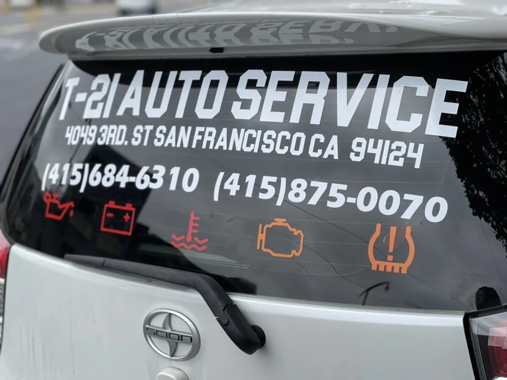 T-21 Auto Service lettering with both phone numbers on a rear window